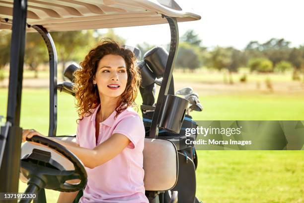 female golfer riding in golf cart at field - professional golfer stock pictures, royalty-free photos & images