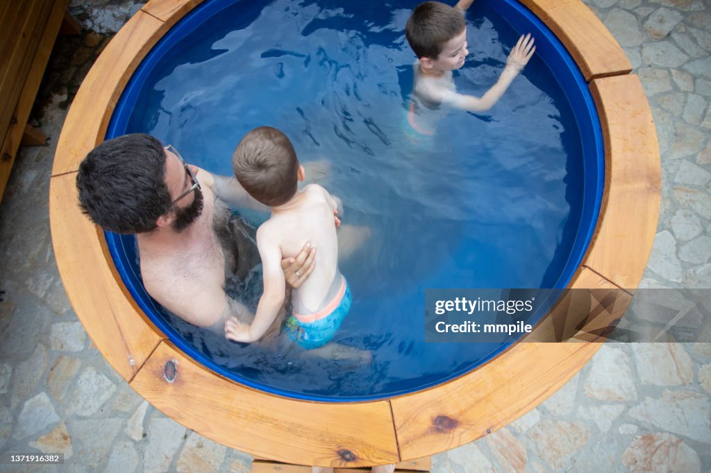 Father and his two boys enjoying in the hot tub during their vacation