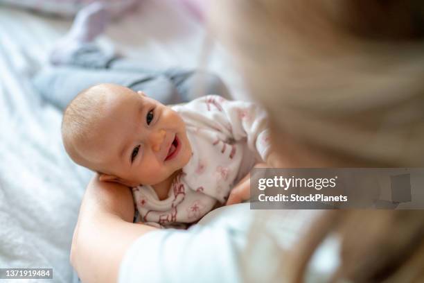 自宅で彼女の女の赤ちゃんを運ぶ女性 - newborn ストックフォトと画像