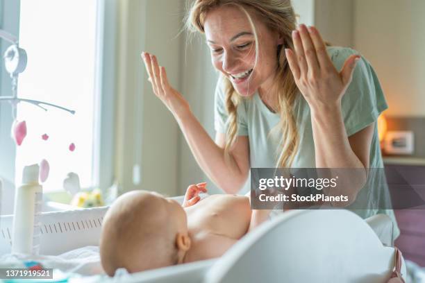 woman changing her baby girl’s diaper - changing diaper imagens e fotografias de stock