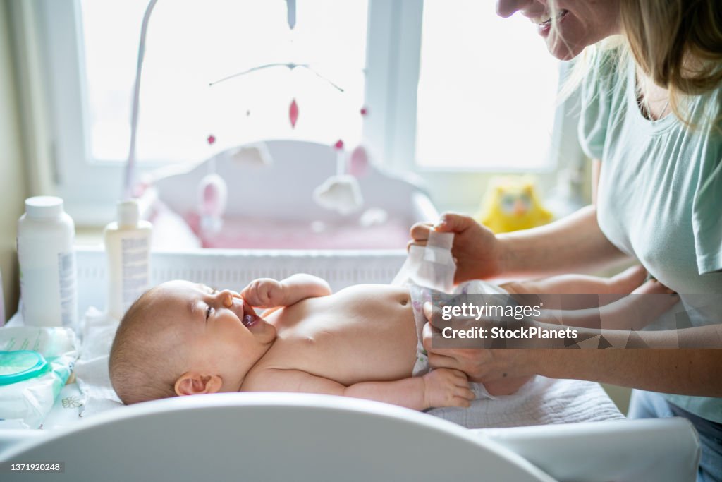Baby in bedroom getting diaper changed