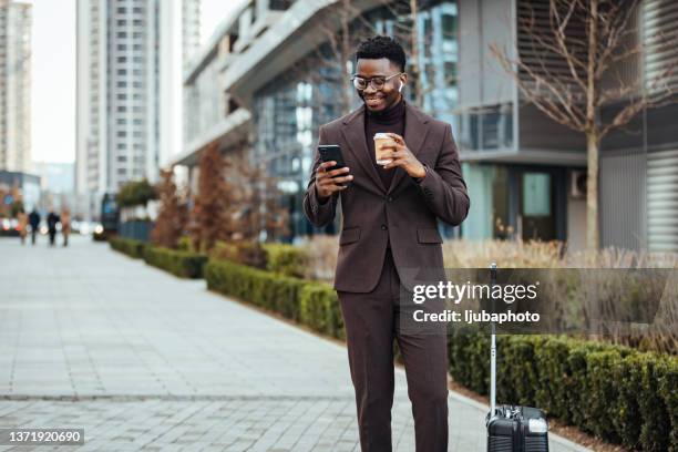 lächelnder geschäftsmann mit smartphone und tasse - business man holding stock-fotos und bilder