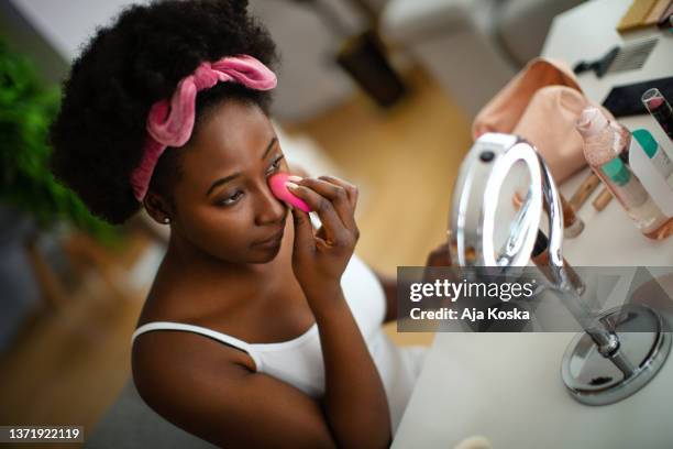 für den anfang trage ich einen concealer auf. - woman applying makeup stock-fotos und bilder