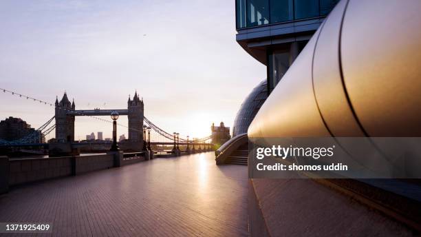 panoramic view across london thames path at sunrise - thames river stockfoto's en -beelden