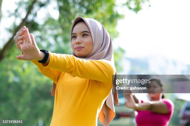 muslim sportswoman stretching and warmup before the sports session - australia training session stock pictures, royalty-free photos & images