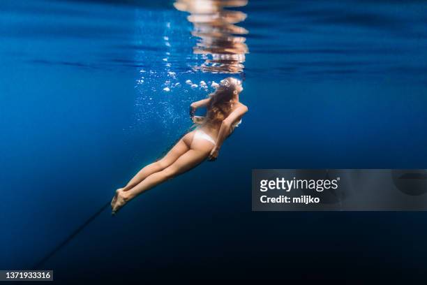 attractive young woman diving in the sea - anchored boats stock pictures, royalty-free photos & images
