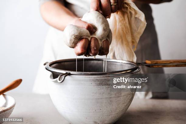 processo di produzione del latte d'avena fatto in casa - scolapasta foto e immagini stock