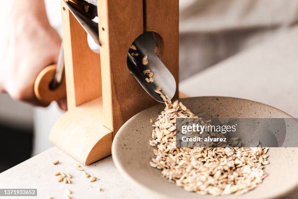 fresh oats from hand grinder machine - avena stock pictures, royalty-free photos & images