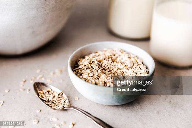 nahaufnahme von bio-haferflocken in einer keramikschüssel - haferflocken stock-fotos und bilder