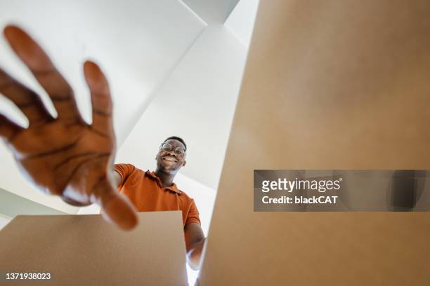 smiling man unpacking things out of box - low angle view room stock pictures, royalty-free photos & images