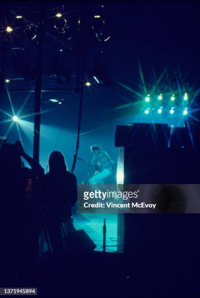View from the side of the stage showing Pete Townshend of The Who jumping in the air while performing on stage at he Kings Hall, Bellevue, Manchester...