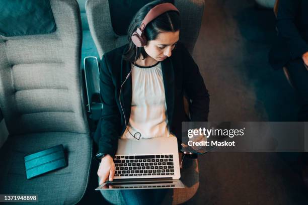 high angle view of businesswoman using various technologies while traveling in train - airport phone stock-fotos und bilder