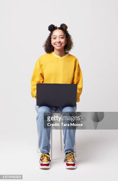 young person sitting in studio with laptop - laptop white background stock-fotos und bilder
