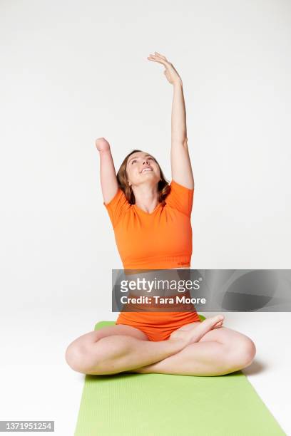 woman with disability doing yoga - schneidersitz stock-fotos und bilder