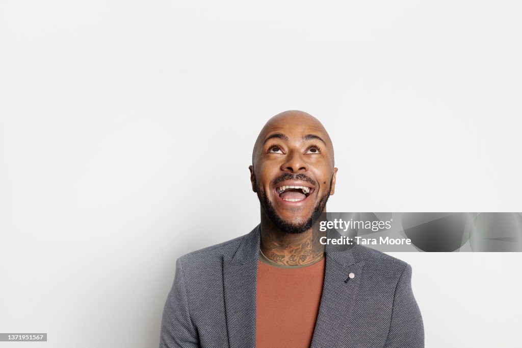 Man smiling looking up against white background