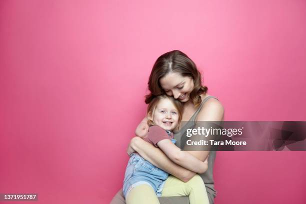 mother and child hugging in pink studio - child portrait studio stock-fotos und bilder