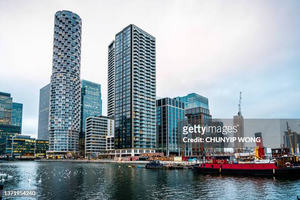 カナリーワーフ、ロンドンの金融と住宅の近代的な地区。ドックの水の高層ビルと光反射 - canary wharf ストックフォトと画像