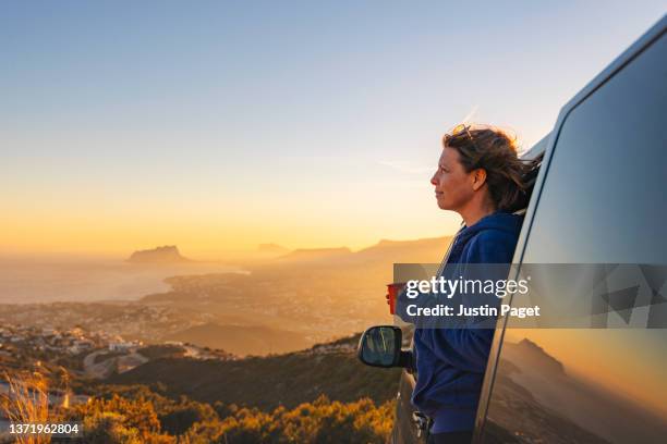 woman taking in the view at sunset from her campervan - trailer imagens e fotografias de stock