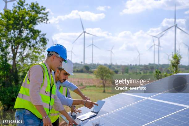 blue collar workers at electricity site. windmill field. - mill worker stock pictures, royalty-free photos & images