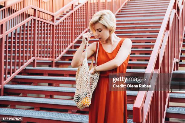 young woman looking into net bag. - portrait looking down stock pictures, royalty-free photos & images