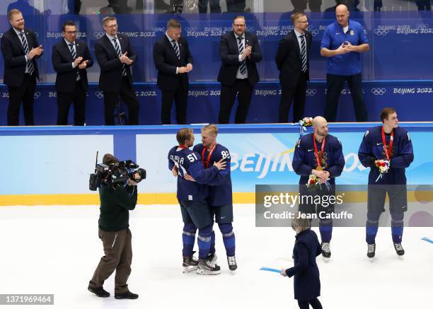 Valtteri Filppula of Finland gives his medal to teammate Harri Pesonen while coach of Finland Jukka Jalonen and his staff look on during the 'Medal...