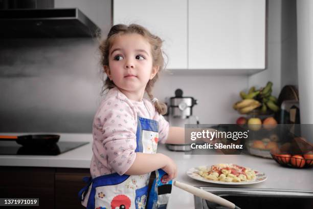 little girl is pouring cheese on pasta - imitation cheese stock pictures, royalty-free photos & images