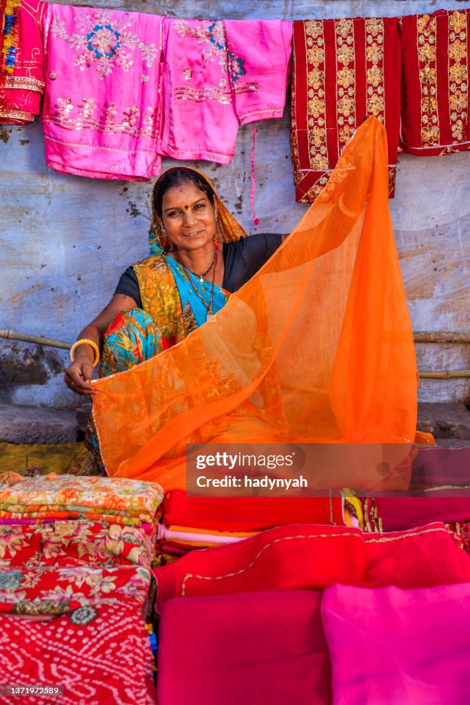 Colors of India - woman selling colorful fabrics on local bazaar