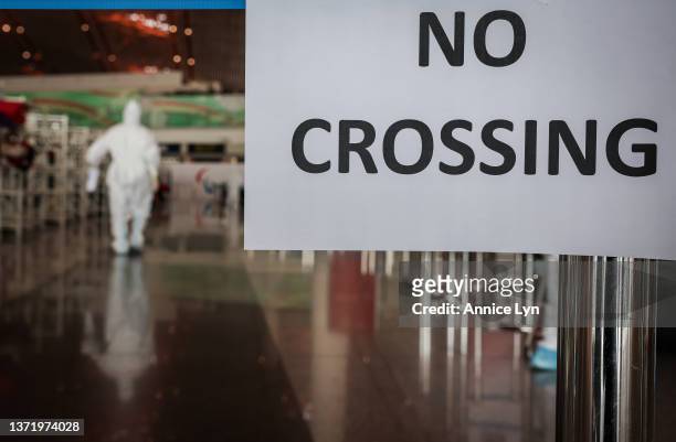 An airport staff member in a hazmat suit works at the Beijing Capital International Airport on February 21, 2022 in Beijing, China. Officials,...