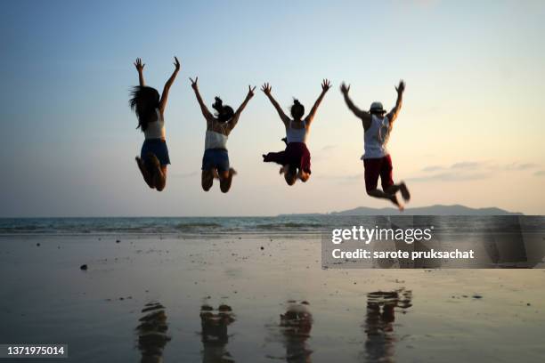 group friends jumping  at the beach . - teen awards bildbanksfoton och bilder