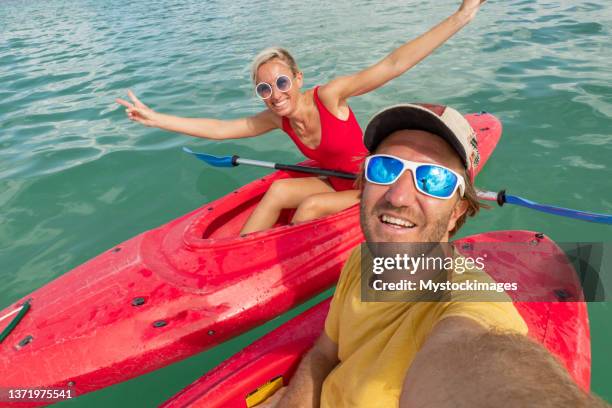 paar kanufahren auf tropischer lagune und urlaub im ausland genießen, selfie - kanu männer stock-fotos und bilder