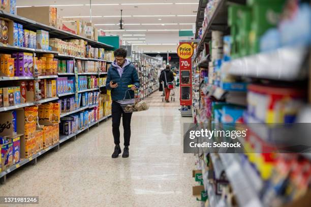 überprüfen der einkaufsliste - supermarktgang stock-fotos und bilder