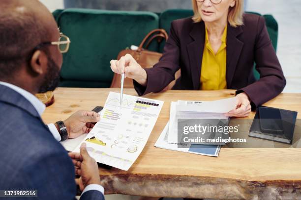 business partners working with documents in team - mediaphotos stock pictures, royalty-free photos & images