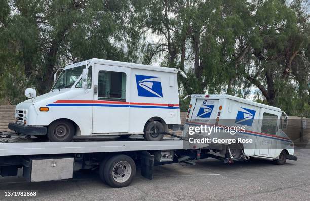 United States Postal Service tow truck prepares to haul away two broken down delivery vehicles on February 15 in Solvang, California. Because of its...