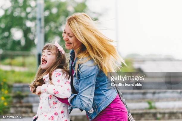 mother having fun and spinning with daughter - cerebral palsy stock pictures, royalty-free photos & images