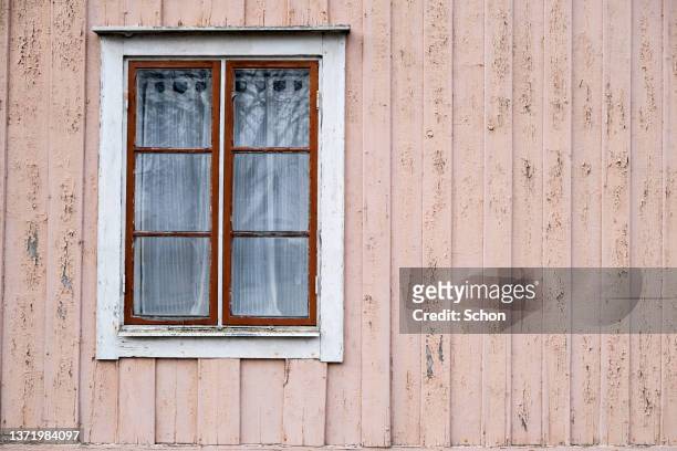 a window in an aged wooden house wall - window frame stock pictures, royalty-free photos & images