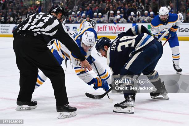 Linesmen Bryan Pancich drops the puck for a face-off between Tage Thompson of the Buffalo Sabres and Boone Jenner of the Columbus Blue Jackets during...