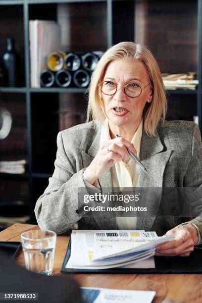 businesswoman sitting at meeting in cafe - mediaphotos stock pictures, royalty-free photos & images