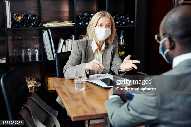 businesswoman having a meeting with colleague at restaurant - mediaphotos stock pictures, royalty-free photos & images