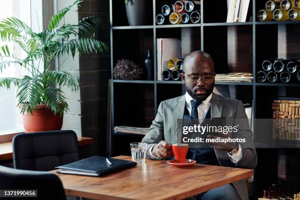 businessman drinking coffee at the restaurant - mediaphotos stock pictures, royalty-free photos & images