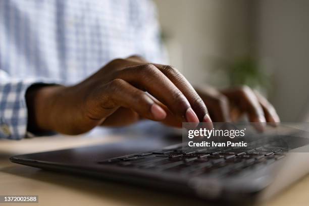 gros plan des mains humaines d’un homme d’affaires afro-américain méconnaissable utilisant un ordinateur portable - focus noir photos et images de collection