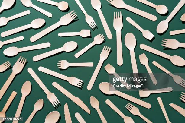 plastic free disposable wooden eating utensils on green background - plastic free stock pictures, royalty-free photos & images