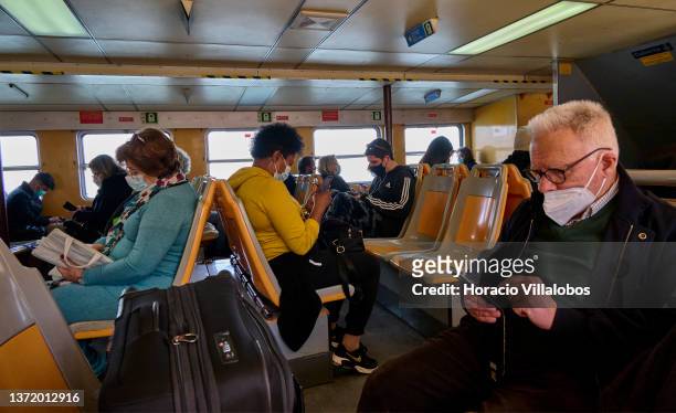 Locals and tourists wear mandatory protective masks while crossing the Tagus River in a Cacilhas-Lisbon ferry during COVID-19 Coronavirus pandemic on...