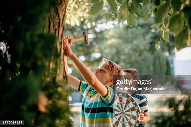 kids playing darts in the back yard - tree service stock pictures, royalty-free photos & images