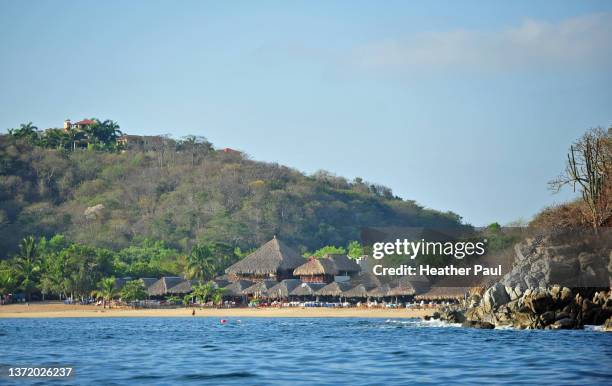 beach and restaurants at bahia maguey in huatulco, mexico - huatulco fotografías e imágenes de stock