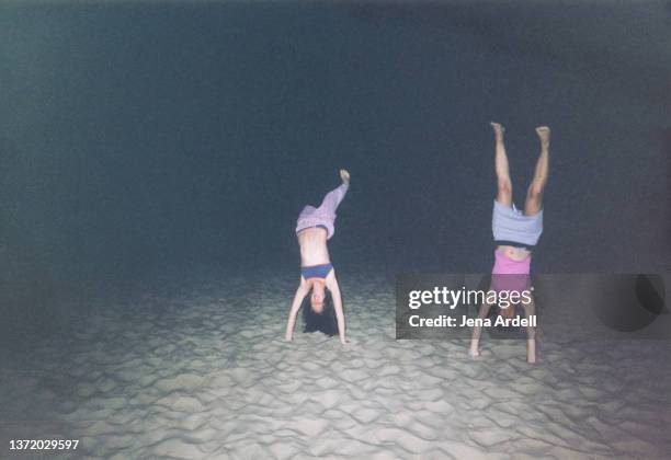 best friends doing handstands on beach, vintage 2000s teens on summer vacation - archival images stock pictures, royalty-free photos & images