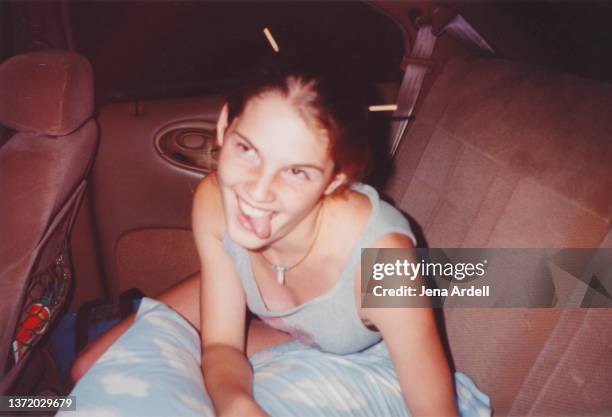 funny vintage road trip young woman making funny face in backseat of car - 90s teens stock-fotos und bilder