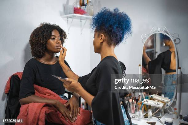maquilladora aplicando maquillaje en los labios de la modelo - maquillador fotografías e imágenes de stock