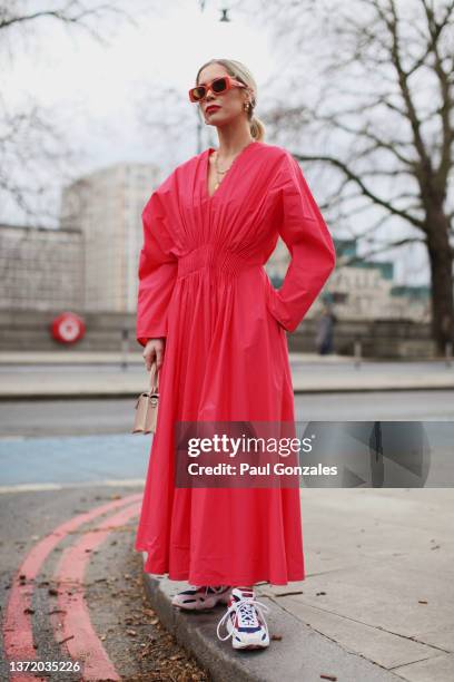 Guest is seen wearing a Pink Dress with a pair of Sneakers at Roksanda during London Fashion Week February 2022 on February 21, 2022 in London,...