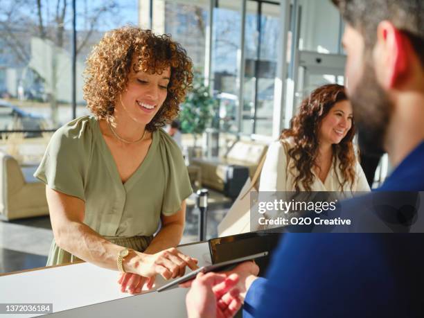 hotel lobby with employees and guests - hotel reception stock pictures, royalty-free photos & images