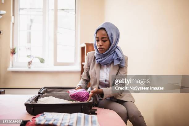 muslim businesswoman packing luggage for the trip - palestinian stockfoto's en -beelden